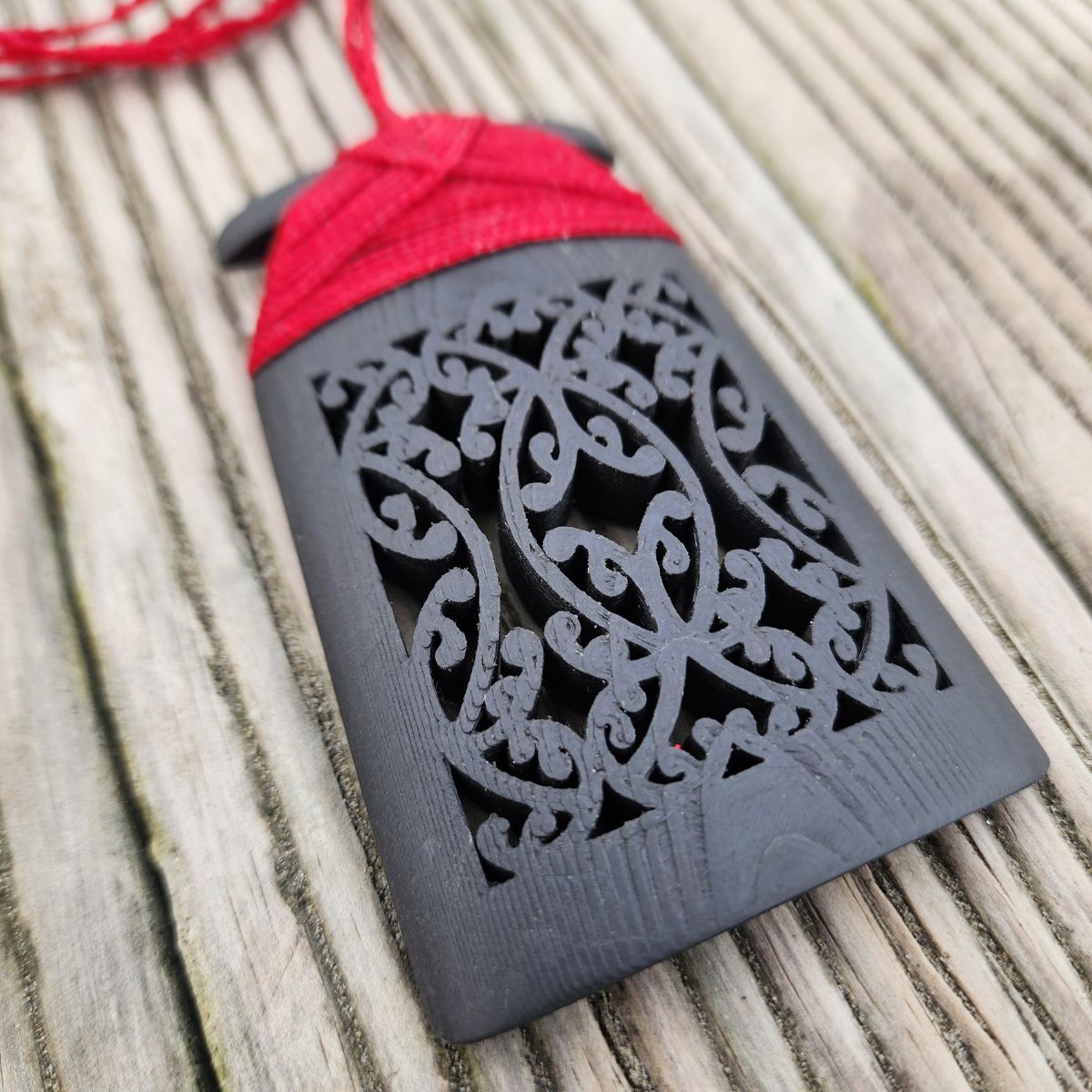 ebony wood toki pendant showing closeup of mangopare hammerhead shark design on the front