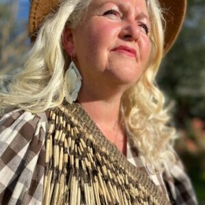 looking into the sun wearing statement feather earrings