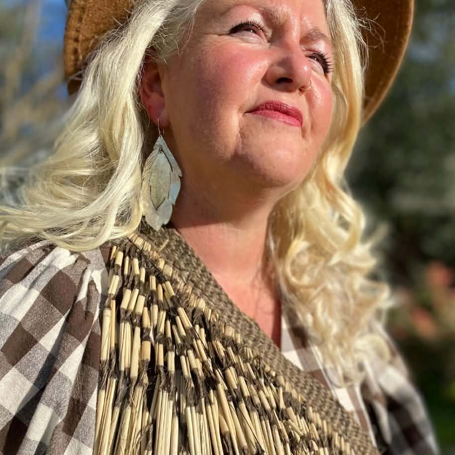 looking into the sun wearing statement feather earrings