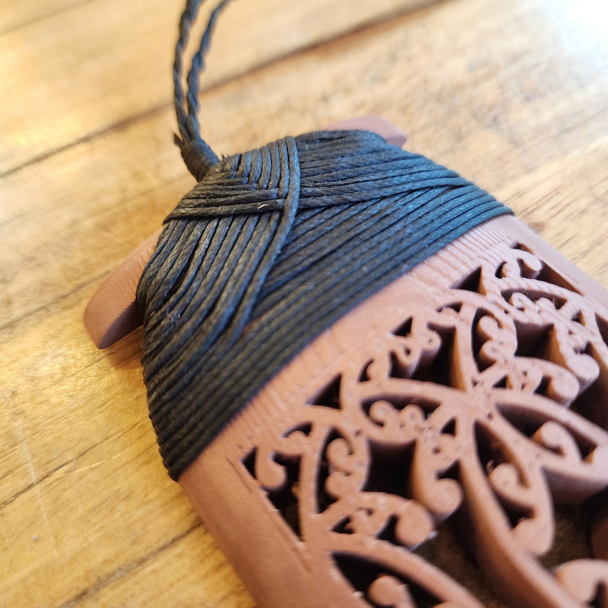 Copper Toki Pendant 3D printed with traditional maori binding in black waxed cord front view with close up of traditional black binding