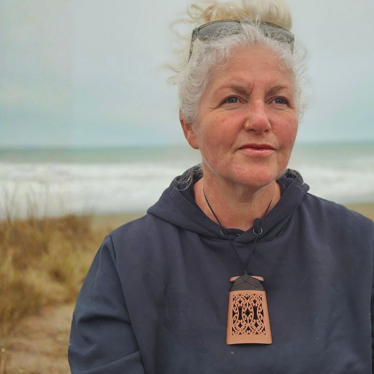 model at the beach wearing copper toki pendant