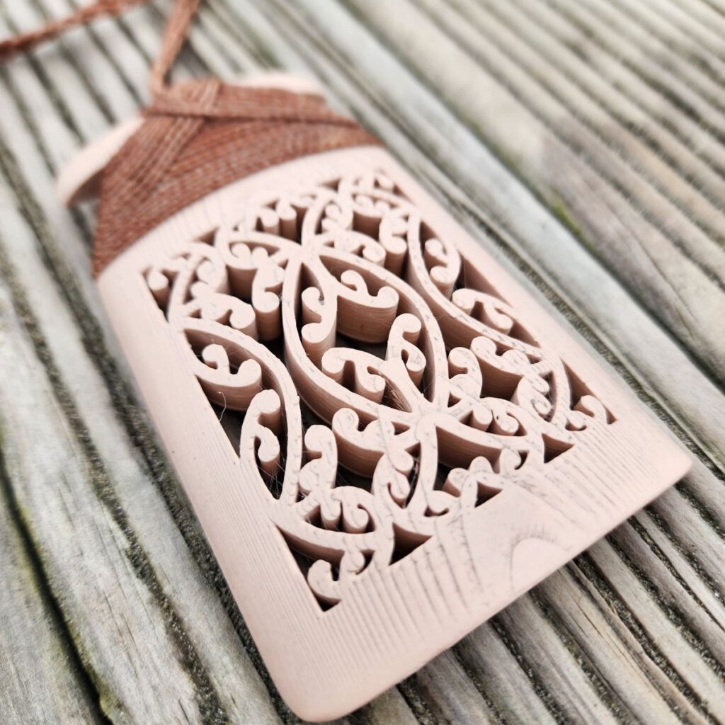 a closeup of the mangōpare design on the bone-white toki necklace