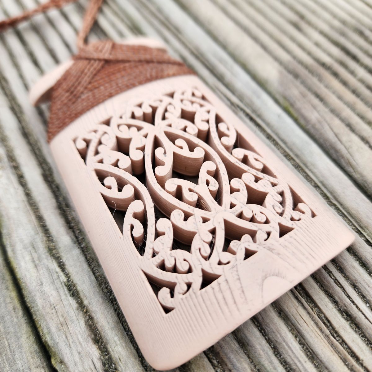 bone coloured 3d printed toki necklace on wooden surface showing mangopare hammerhead shark design