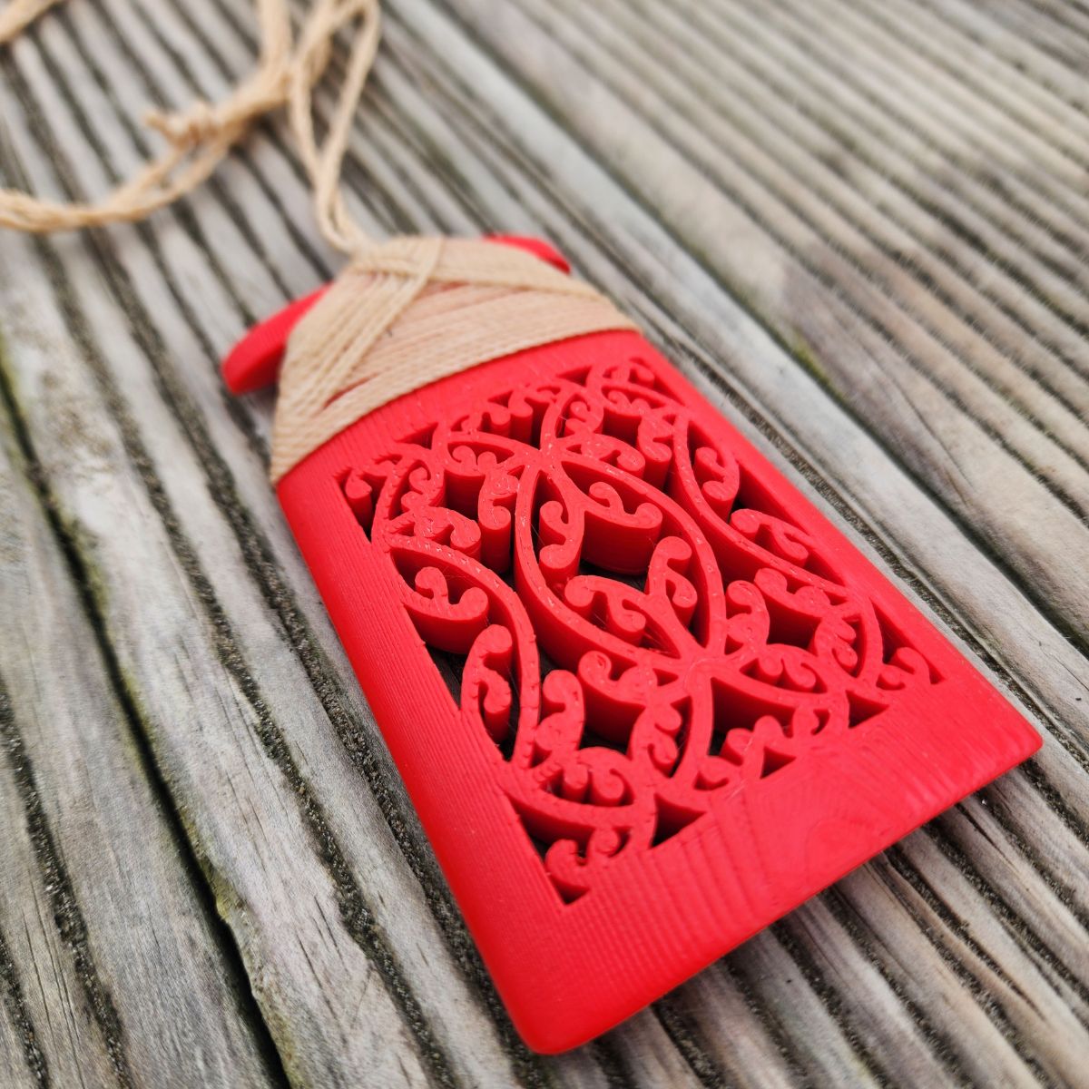 red coloured 3d printed toki necklace showing closeup of mangopare hammerhead shark design