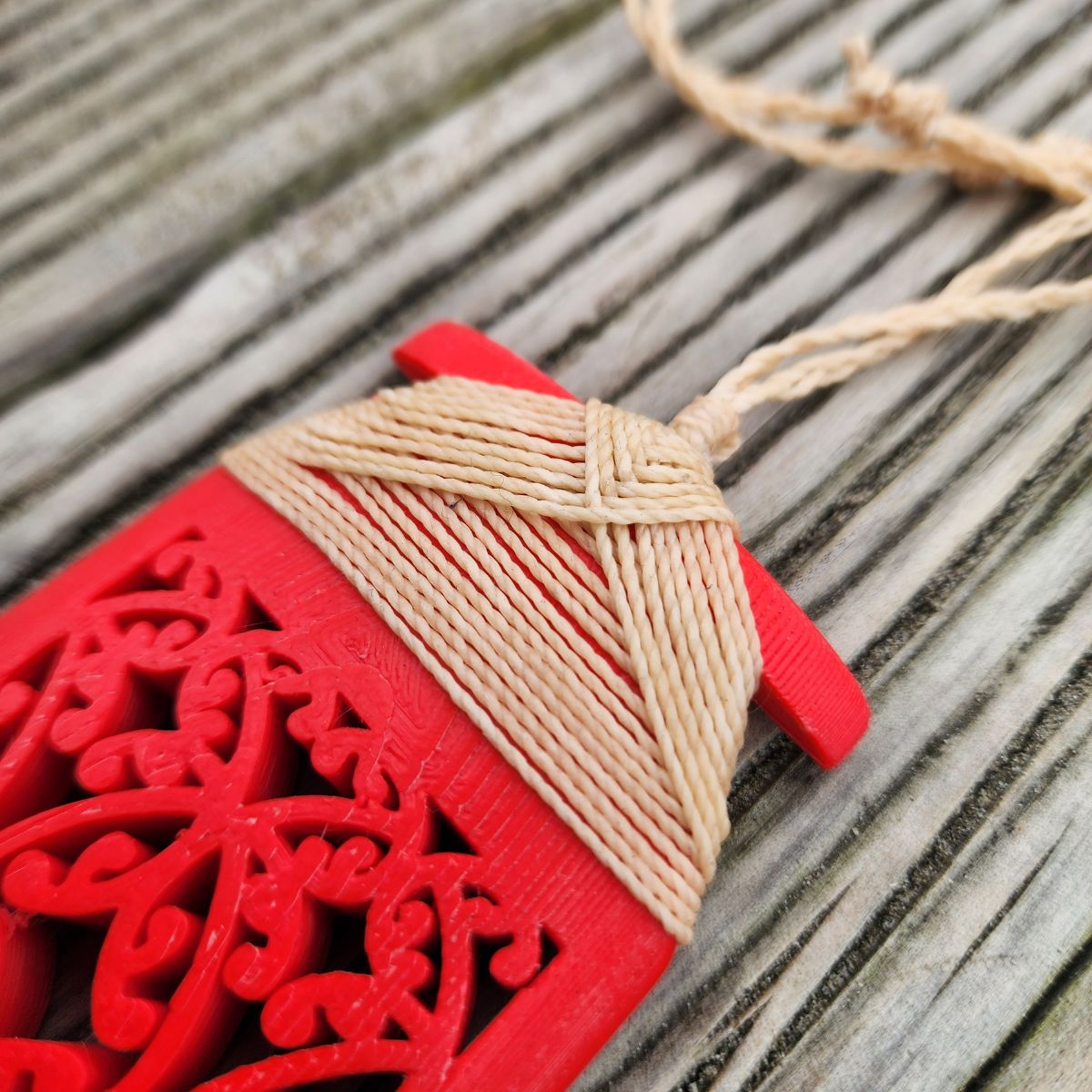 red coloured 3d printed toki necklace showing closeup of the natural linen coloured binding