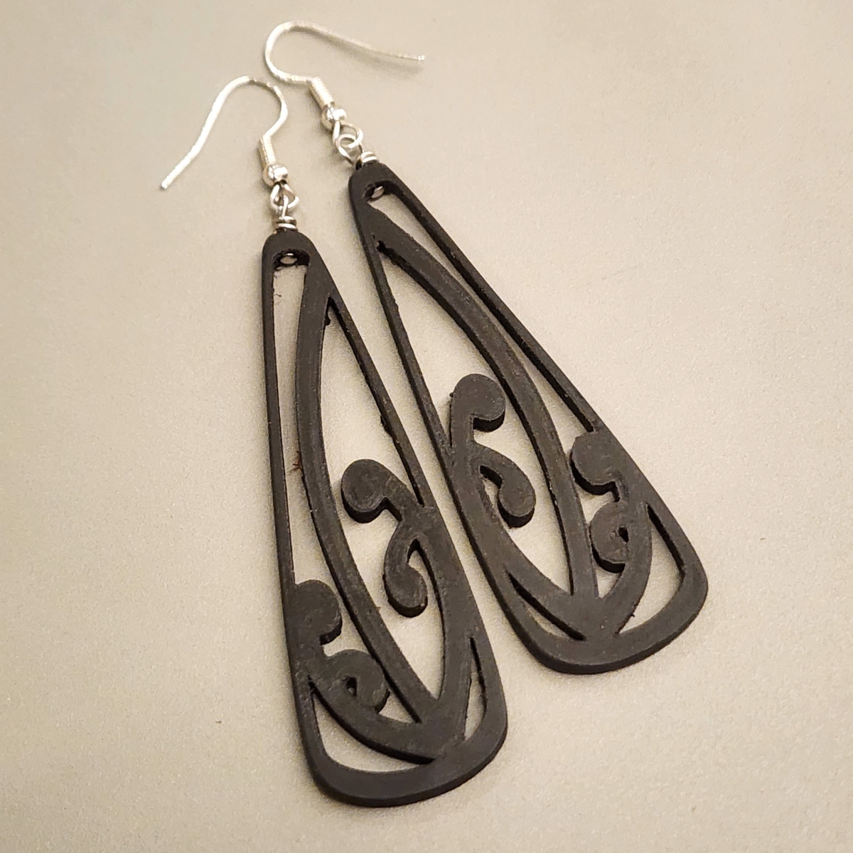 a closeup view of the ebony wood black manōpare toki earrings