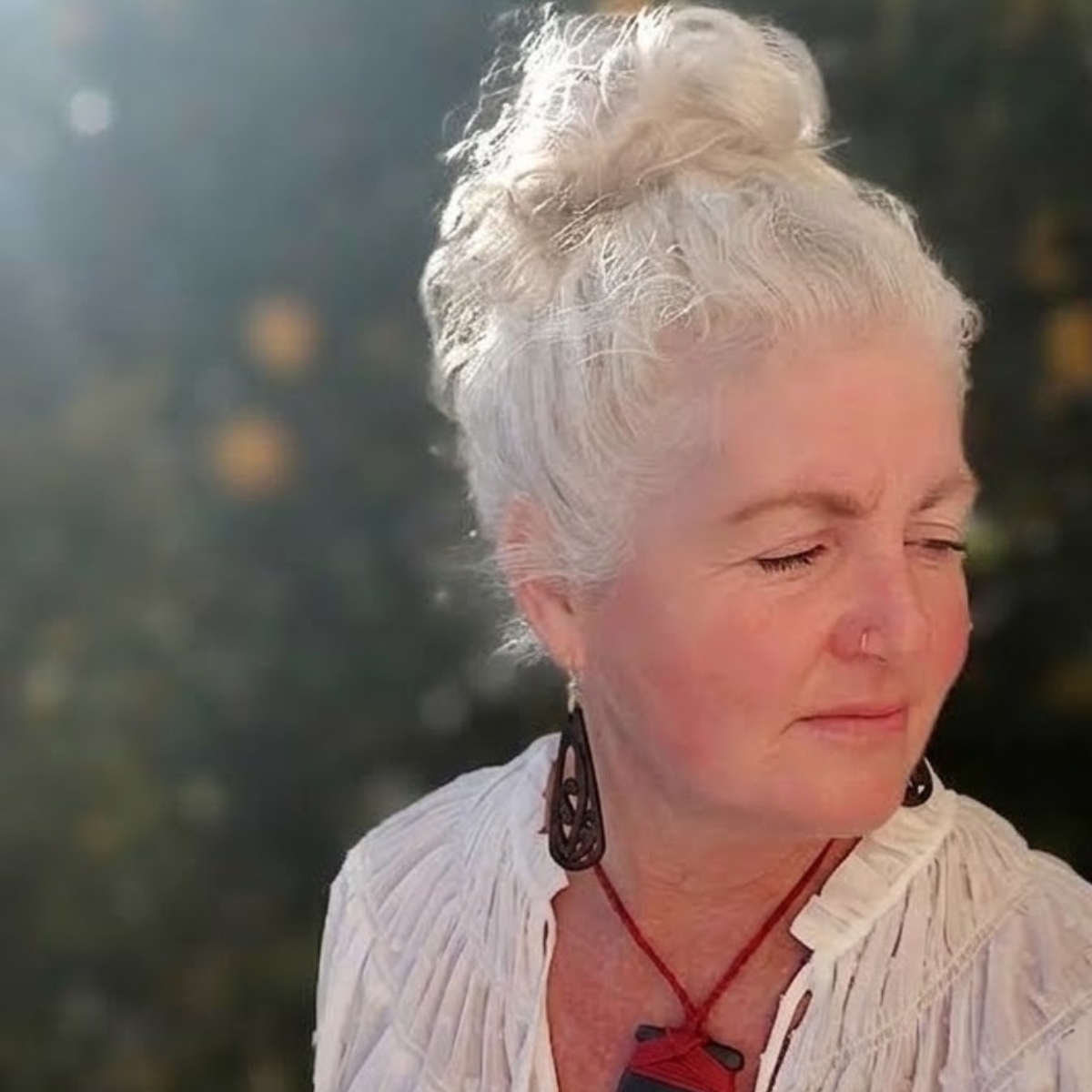 model in the late afternoon sunlight wearing ebony wood black mangōpare earrings