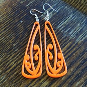 Orange toki mangopare earrings on dark wood background