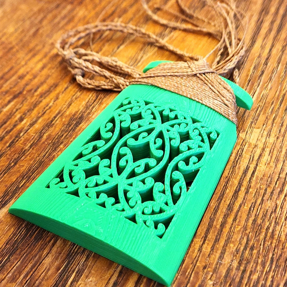 Green manōpare toki necklace showing close up of the mangōpare lattice design