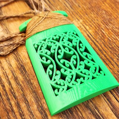 Green mangōpare necklace with brown binding on a wooden surface