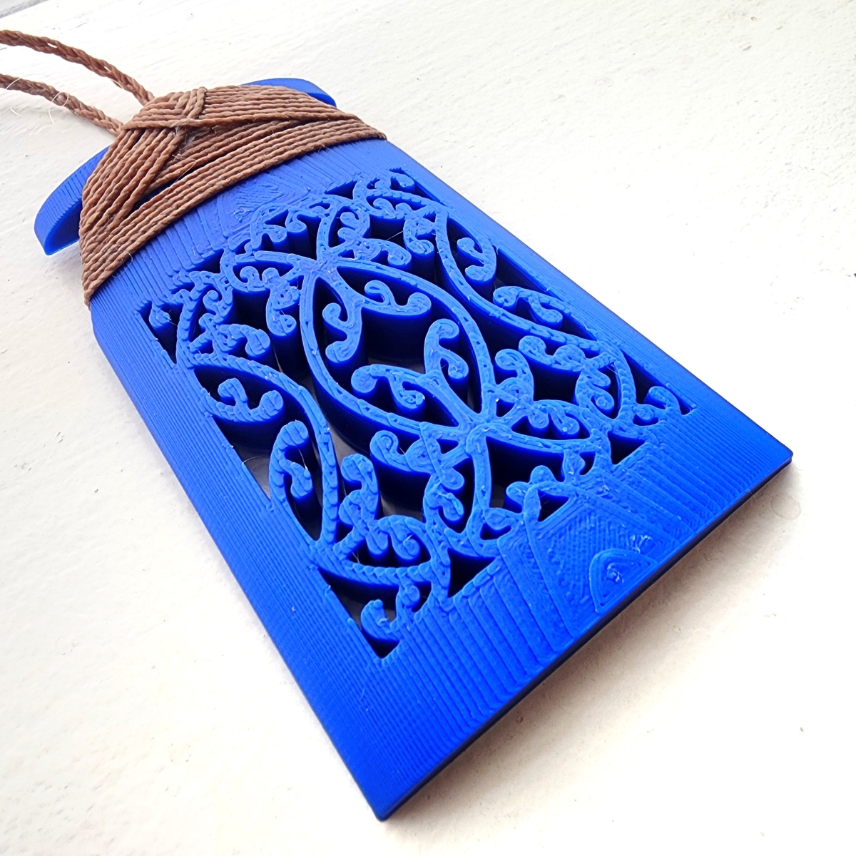 close up of the mangopare design on the front of blue toki necklace