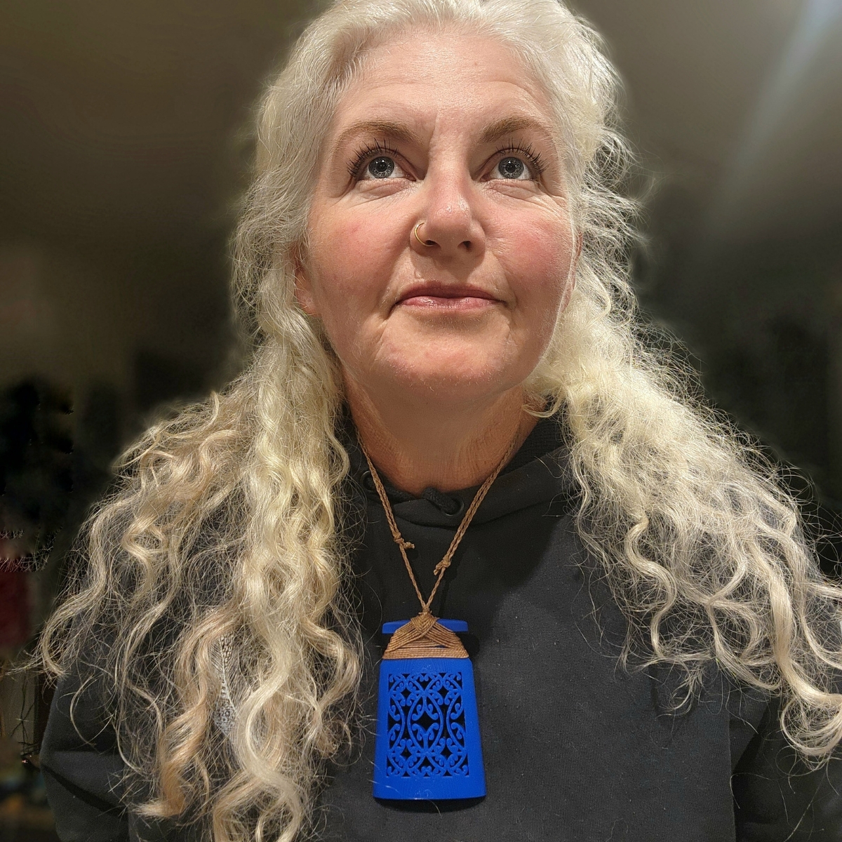 woman with long white hair wearing blue toki necklace