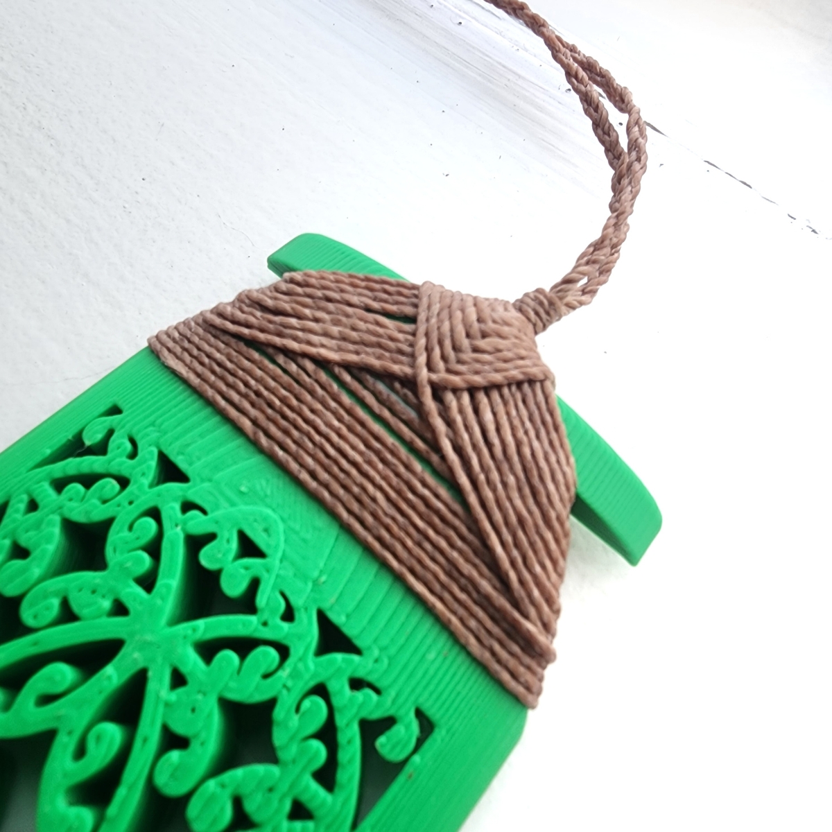 closeup of traditional binding on green toki necklace