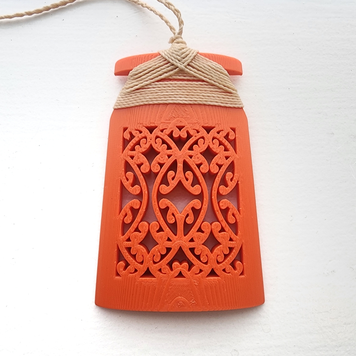 orange toki necklace with traditional binding on a white background