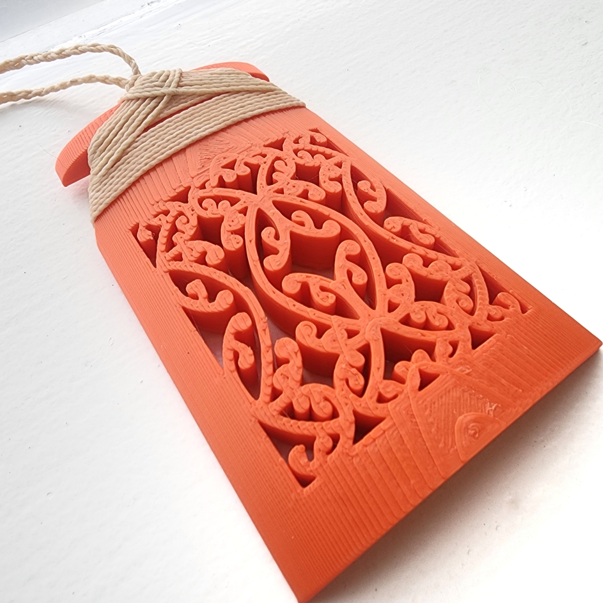 closeup of the mangopare detail on orange toki necklace