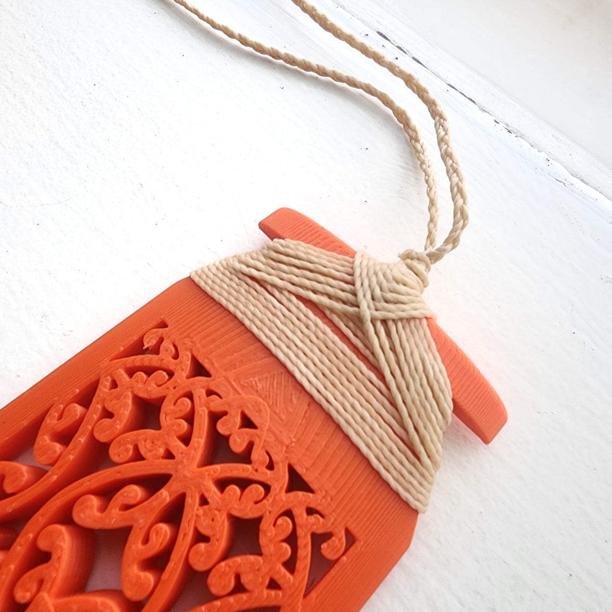 closeup of traditional binding on orange toki necklace